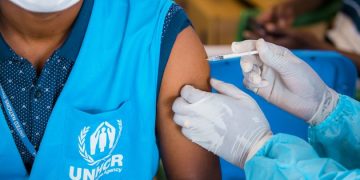 Excluding migrants undermines the success of COVID-19 vaccine rollouts